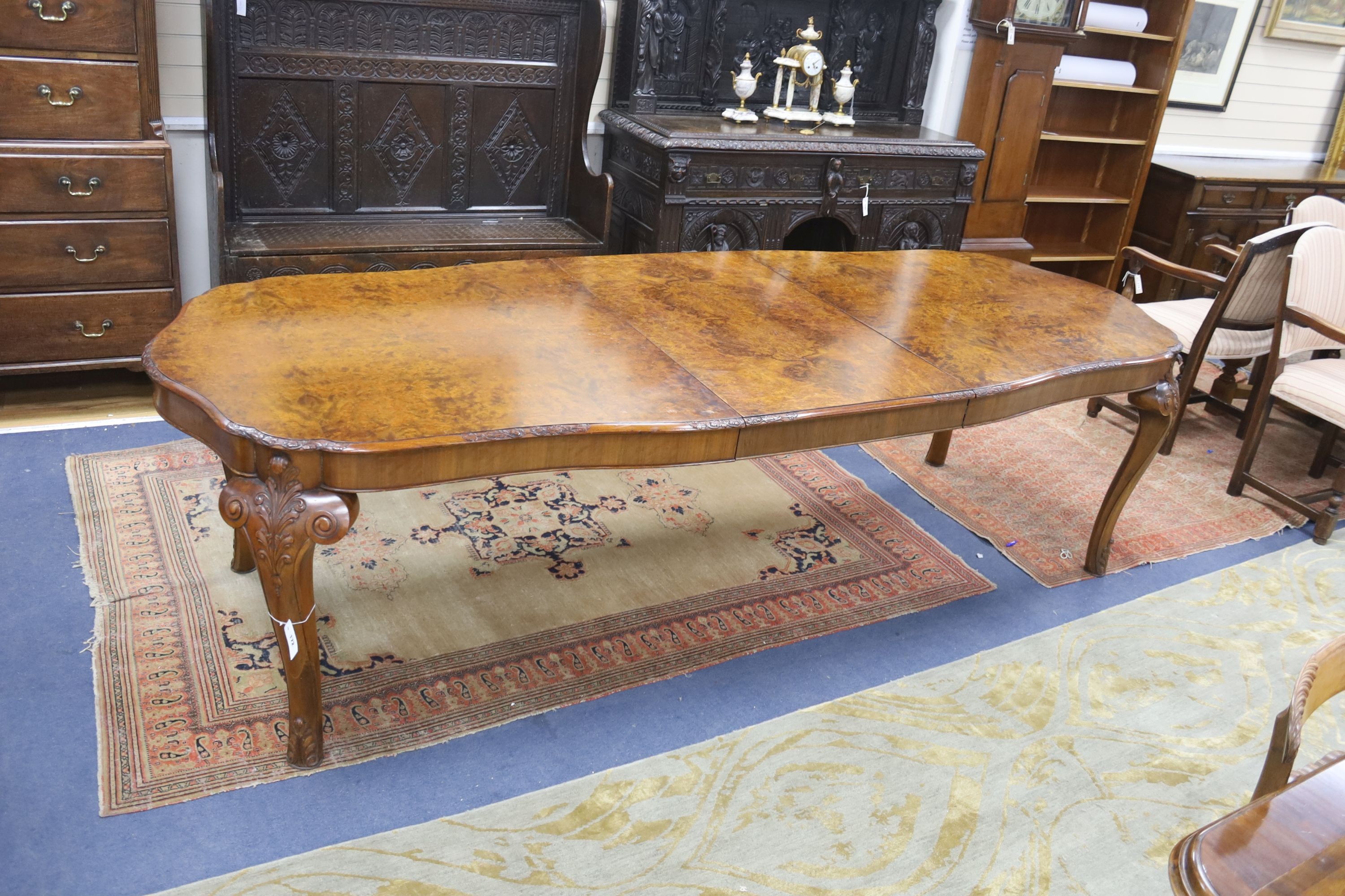 A Queen Anne revival burr walnut shaped oval extending dining table, 272cm extended, one spare leaf, width 106cm, height 75cm